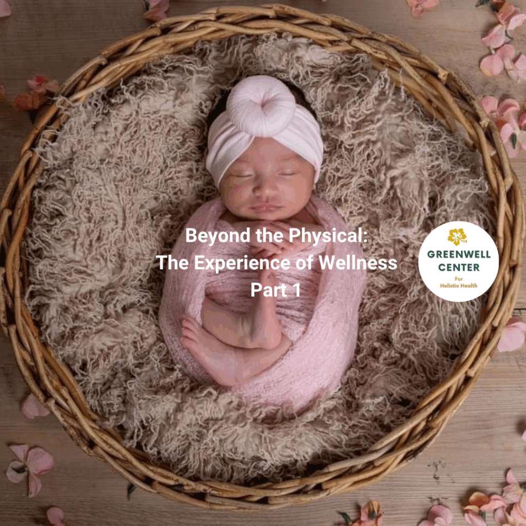 New born baby with head wrap and body wrap surrounded by a wreath, sleeping