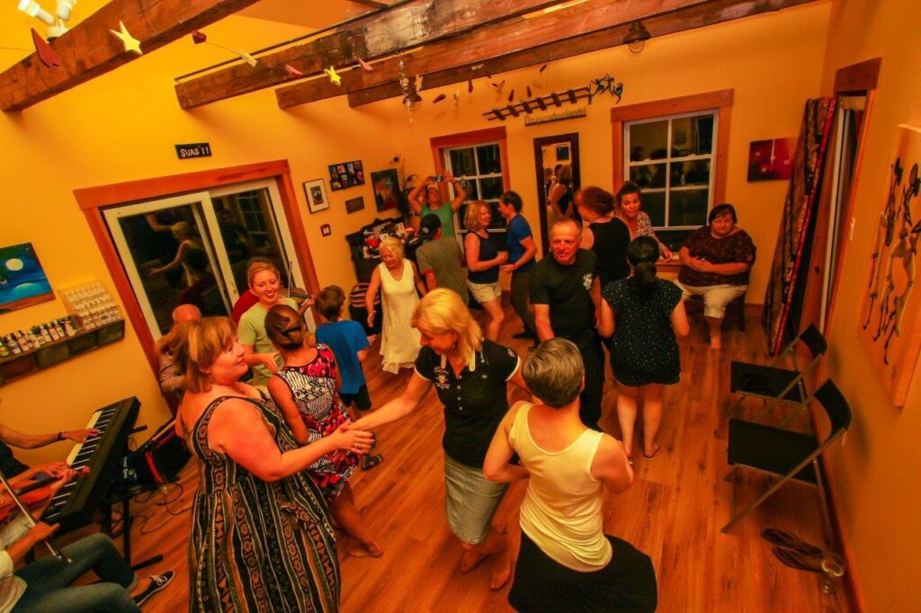 room full of people dancing and musicians playing, a cape breton kitchen party