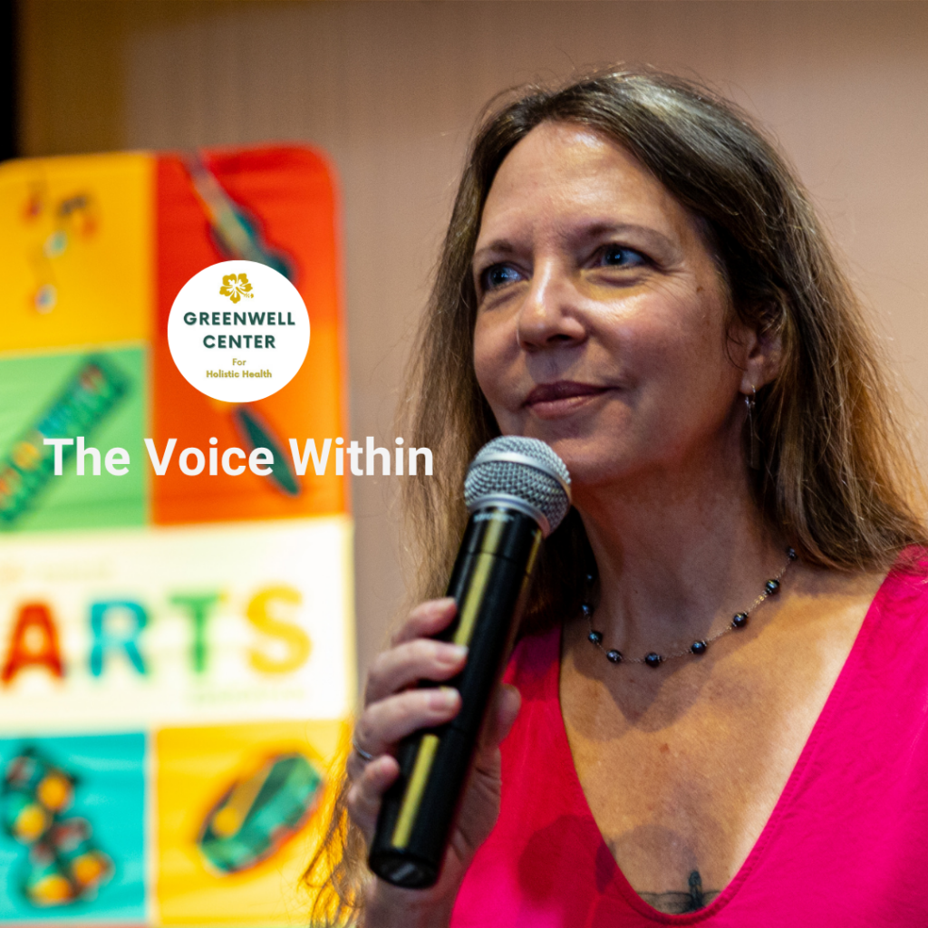 woman with long hair holding a microphone, poster behind her says "arts"