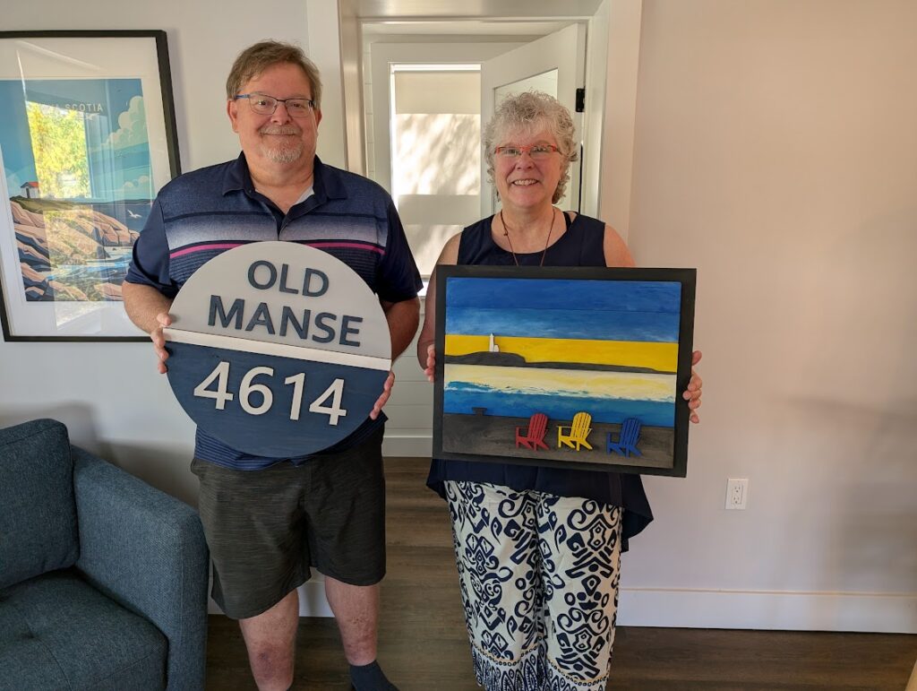 Man and Woman in their 60's holding art they painted