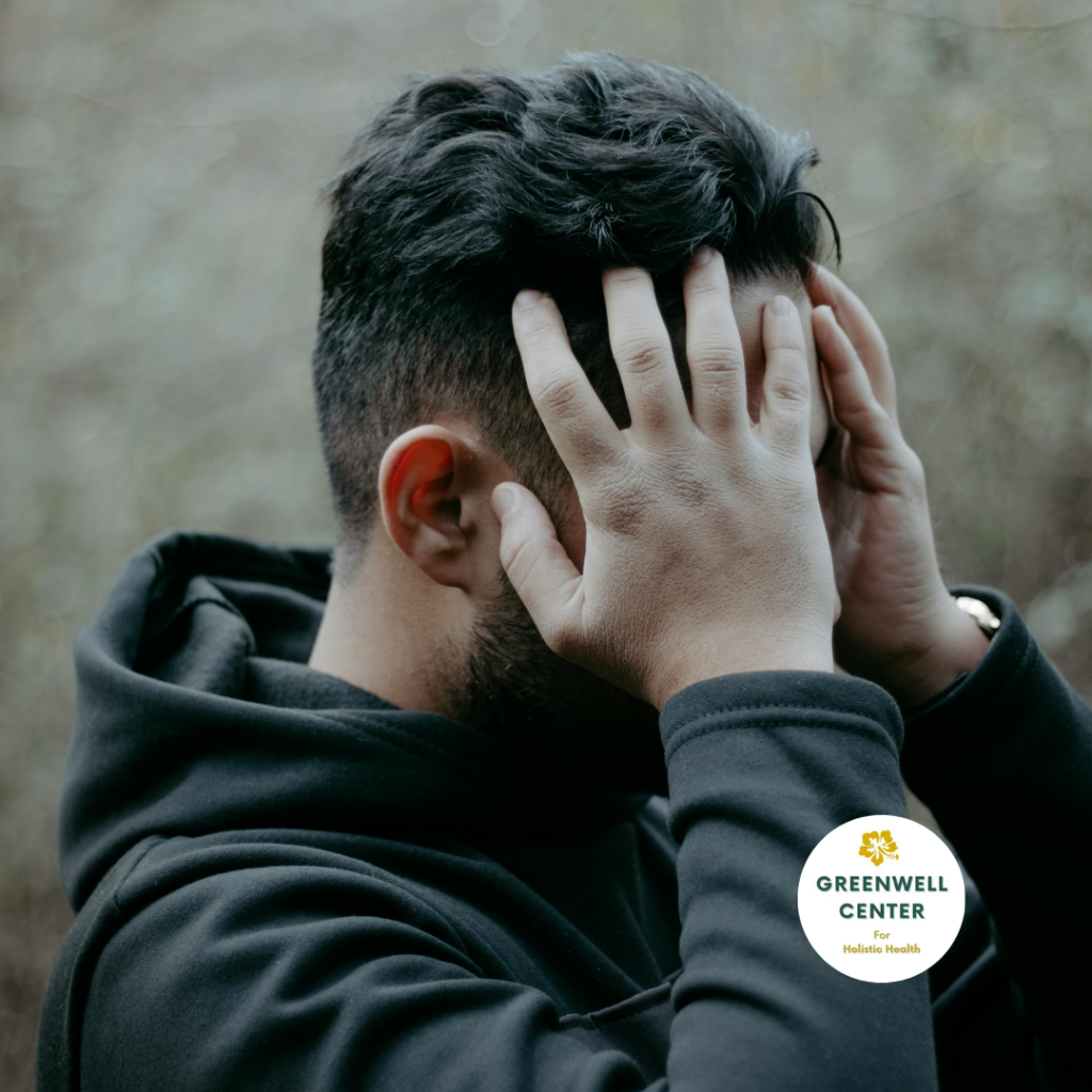 man holding his head, touching his emotional stress release points on the forehead with his fingertips