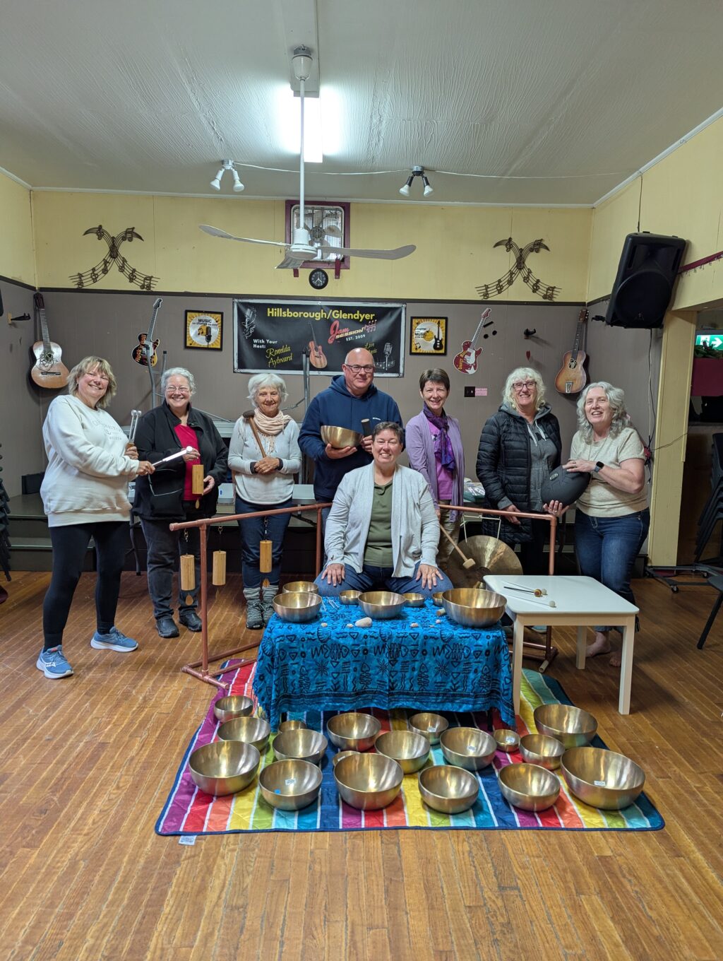 Singing bowls, koshi chimes, gong and sound bath with a group of people gathered for the photo